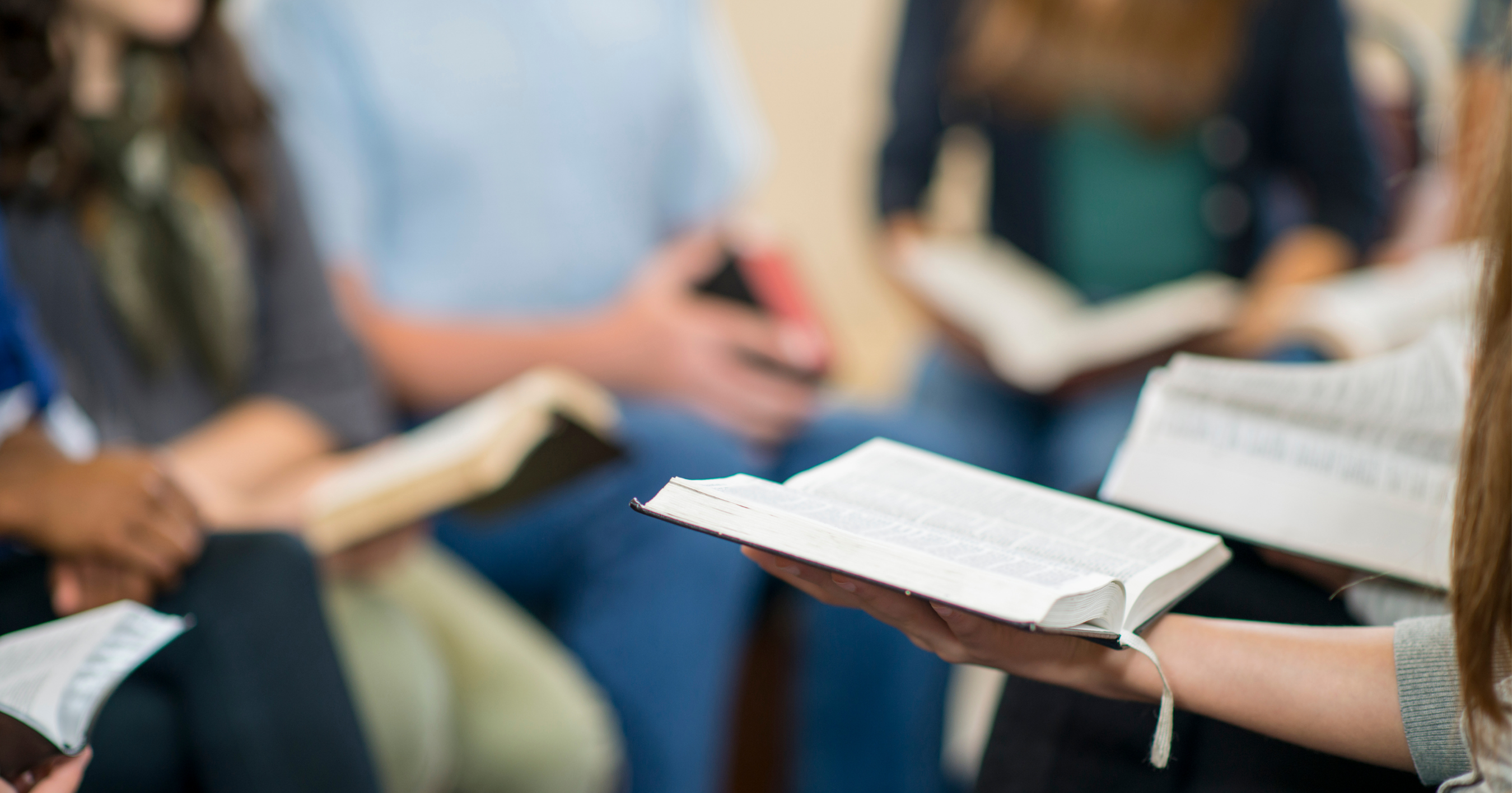 Church small group Bible study with open Bibles, leaders guiding discipleship and spiritual formation.